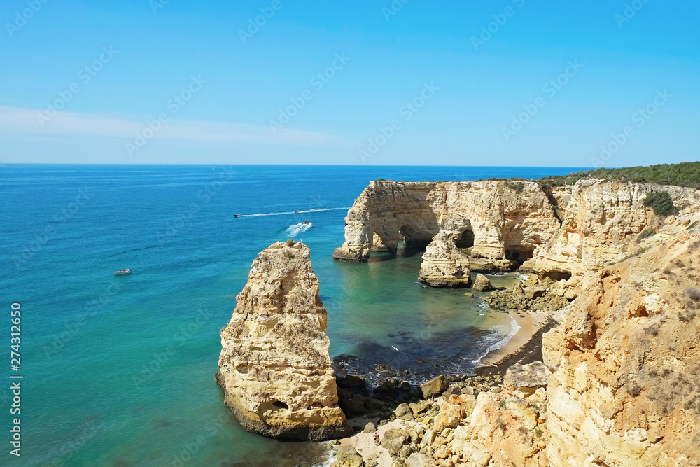 Rocky beaches with cliffs somwhere, somwhere in Algarve, Portugal. Atlantic ocean shore background. Copy space for text.