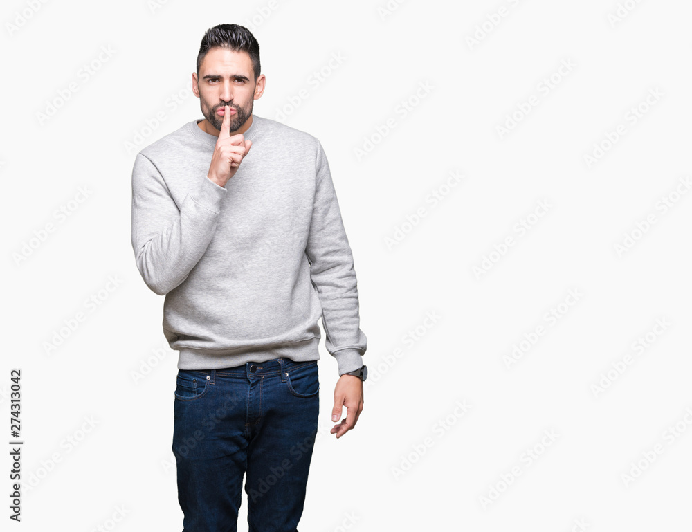 Fototapeta premium Young handsome man wearing sweatshirt over isolated background asking to be quiet with finger on lips. Silence and secret concept.