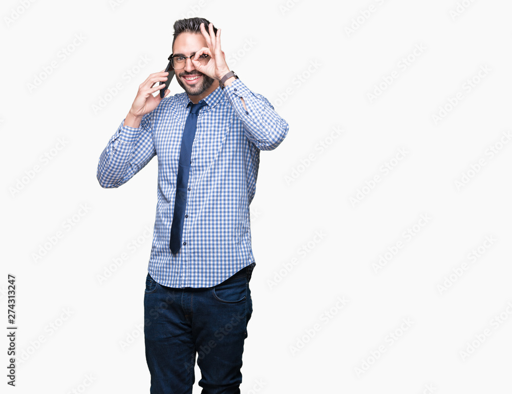 Young business man talking on the phone over isolated background with happy face smiling doing ok sign with hand on eye looking through fingers Young business man talking on the phone over isolated background with happy face smiling doing ok sign with hand on eye looking through fingers