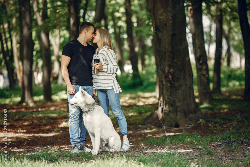 Couple in a forest. Pair playing with a cute dog Couple in a forest. Pair playing with a cute dog