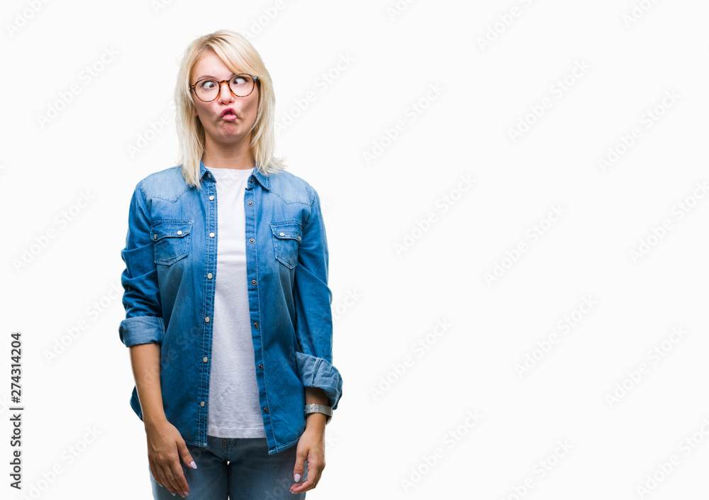 Young beautiful blonde woman wearing glasses over isolated background making fish face with lips, crazy and comical gesture. Funny expression. Young beautiful blonde woman wearing glasses over isolated background making fish face with lips, crazy and comical gesture. Funny expression.