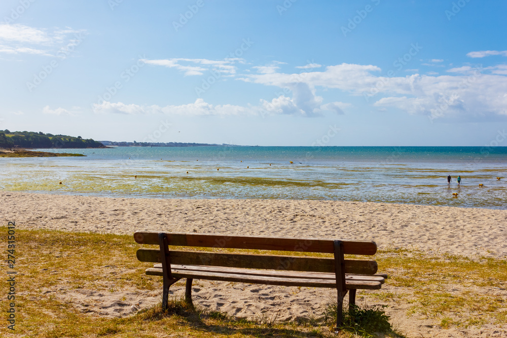 Bench with a view of a beautiful beach in Kerleven, Brittany, France, on a sunny day