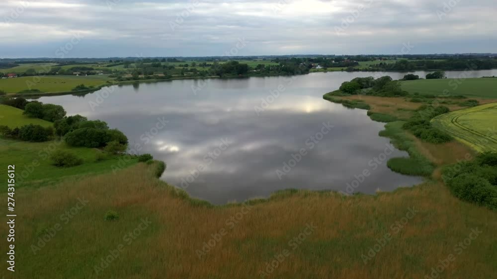 Crystal clear water reflecting dark clouds near Roskilde. Drone aerial view Crystal clear water reflecting dark clouds near Roskilde. Drone aerial view