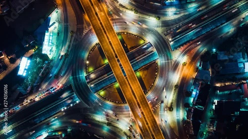 Beautiful top view time-lapse of car traffic at roundabout lane and buildings. 4K drone aerial zoom out. Urban cityscape concept or abstract of advanced innovation, financial technology, energy power photo