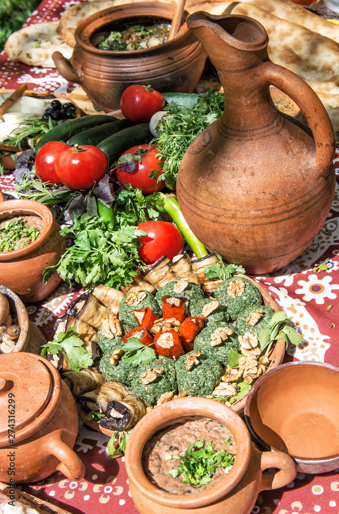 Fototapeta premium Georgian food Lobio vegetables herbs Dinner table