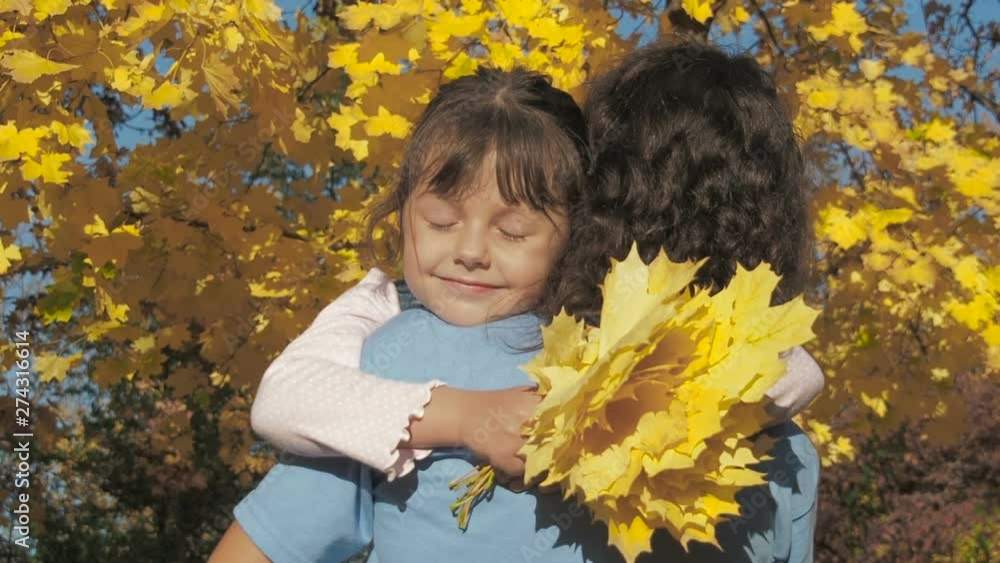 Child hugs mother outside. Happy little girl hugs mom in autumn outdoors. Child hugs mother outside. Happy little girl hugs mom in autumn outdoors.