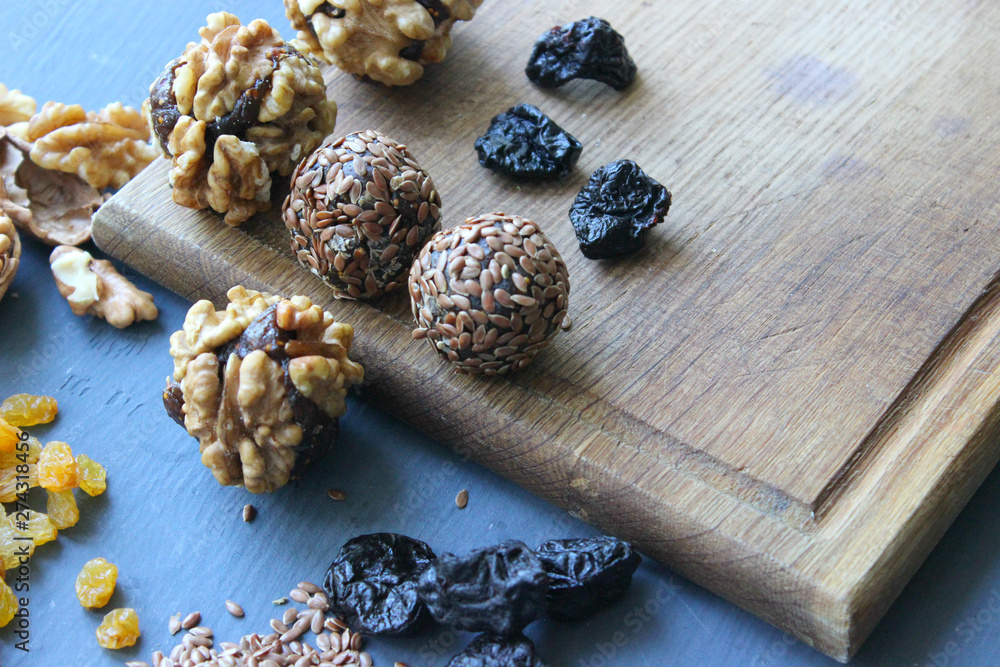 Homemade healthy raw vegan sweet balls with nuts,raisins, dates, cocoa and flax seeds. Healthy vegan food concept. Gray background. Homemade healthy raw vegan sweet balls with nuts,raisins, dates, cocoa and flax seeds. Healthy vegan food concept. Gray background.