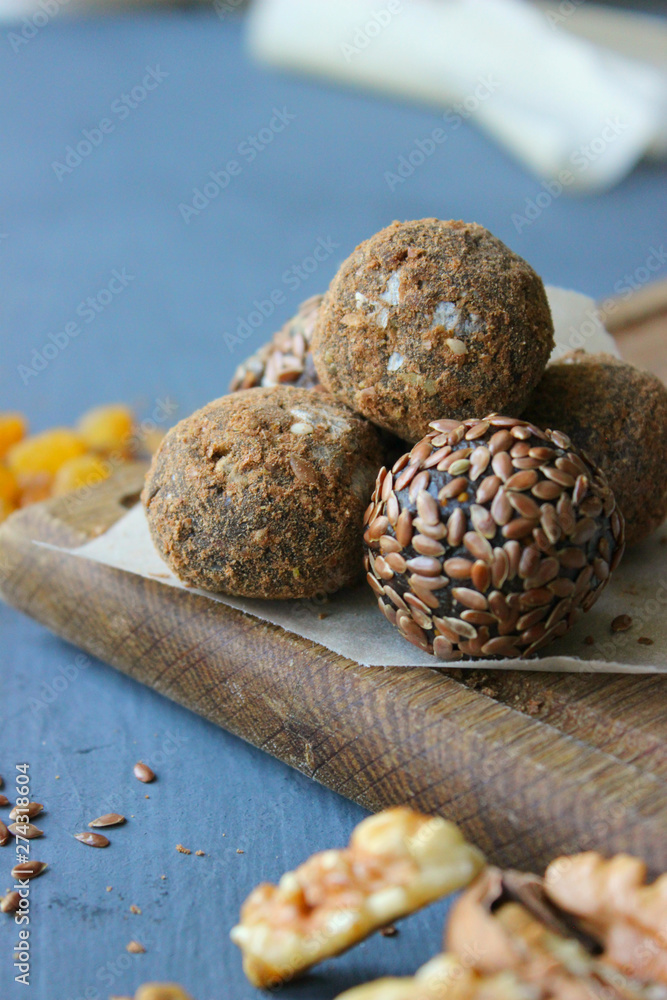 Homemade healthy raw vegan sweet balls with nuts,raisins, dates, cocoa and flax seeds. Healthy vegan food concept. Gray background.