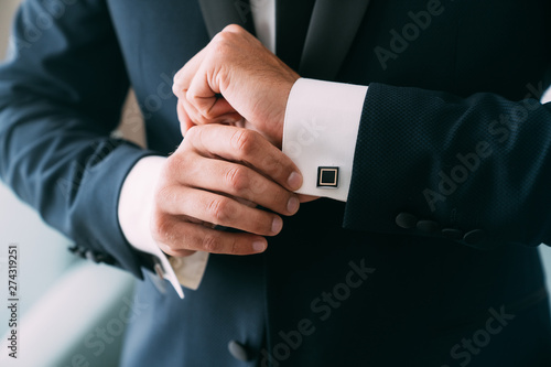 Schilderij op canvas Close-up groom hands puts on cufflinks