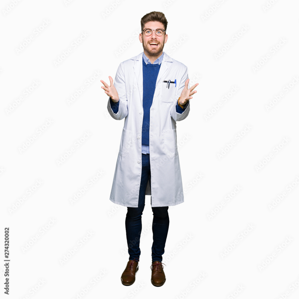 Young handsome scientist man wearing glasses celebrating crazy and amazed for success with arms raised and open eyes screaming excited. Winner concept Young handsome scientist man wearing glasses celebrating crazy and amazed for success with arms raised and open eyes screaming excited. Winner concept