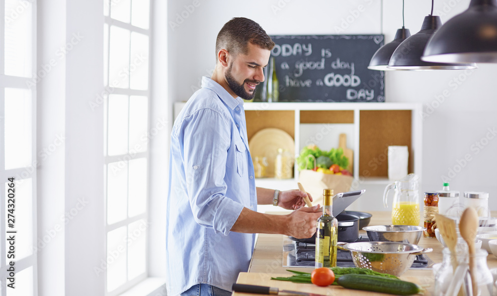Smiling and confident chef standing in large kitchen Smiling and confident chef standing in large kitchen
