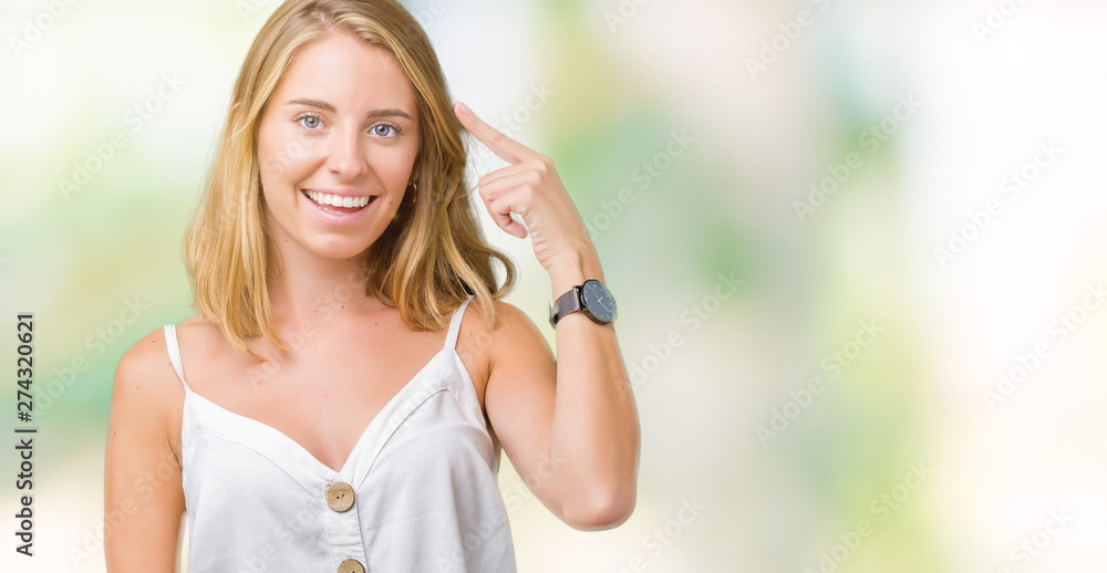 Beautiful young woman over isolated background Smiling pointing to head with one finger, great idea or thought, good memory