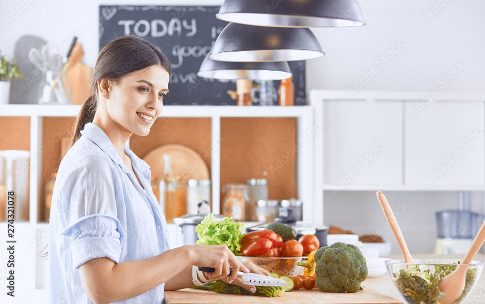 A young woman prepares food in the kitchen. Healthy food - vegetable salad. Diet. The concept of diet. Healthy lifestyle. Cook at home. Cook
