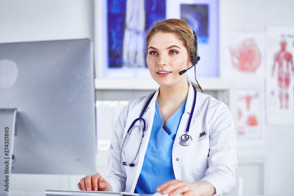 Portrait of a happy smiling young doctor in headset in office Portrait of a happy smiling young doctor in headset in office