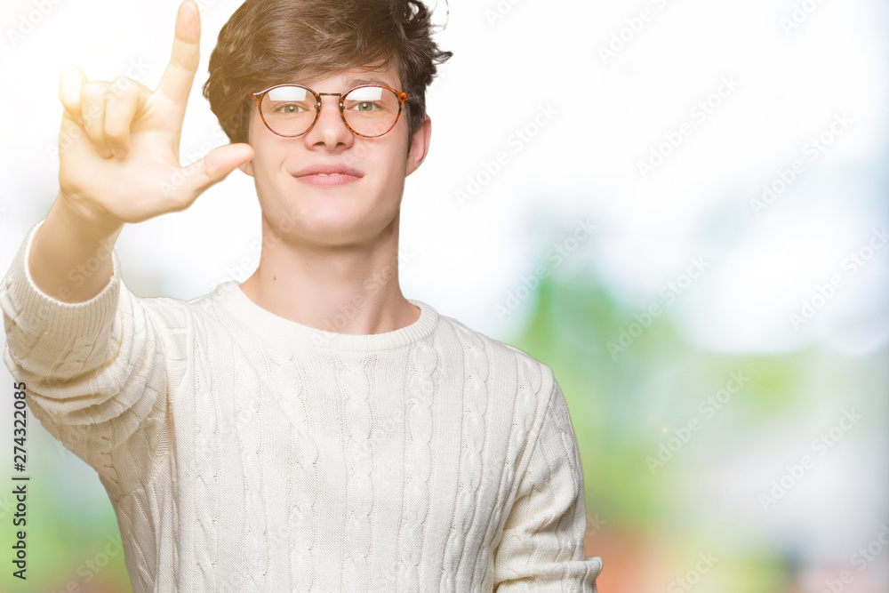 Young handsome man wearing glasses over isolated background showing and pointing up with fingers number two while smiling confident and happy.