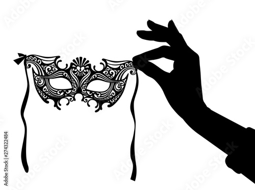 Silhouette of female hand with a decorative carnival Venetian mask
