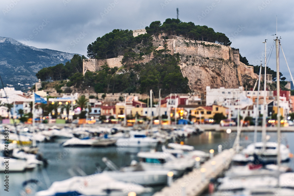 DENIA, SPAIN - JUNE 13, 2019: Panoramic view of Denia port promenade and castle.