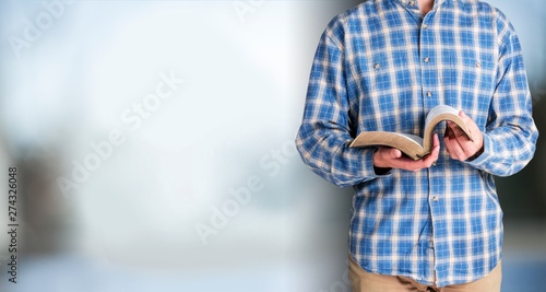 Man reading old heavy book on background
