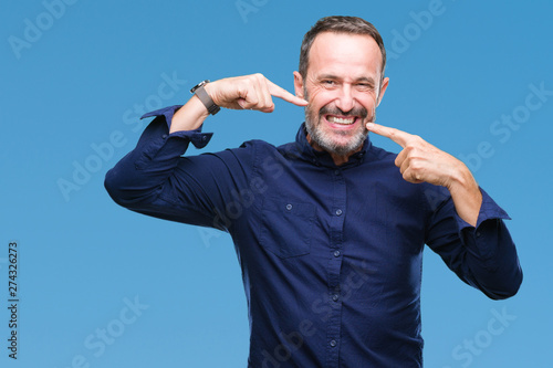 Middle age hoary senior man over isolated background smiling confident showing and pointing with fingers teeth and mouth. Health concept.