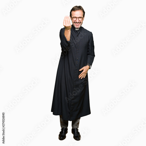 Middle age priest man wearing catholic robe Doing Italian gesture with hand and fingers confident expression