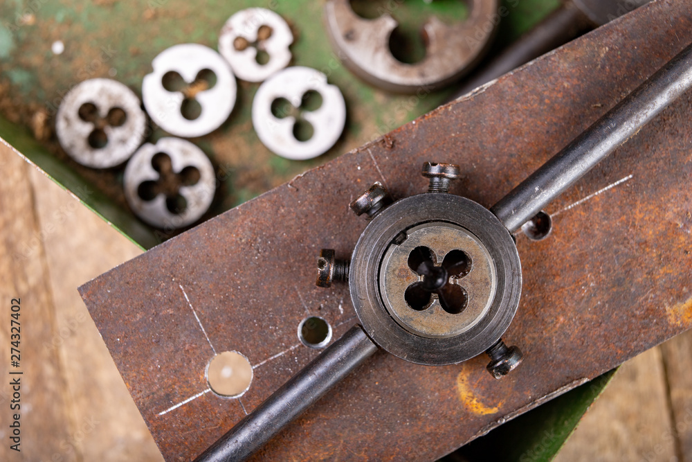 Fototapeta premium Manual thread cutting in metal. Locksmith accessories for small work in the home workshop.
