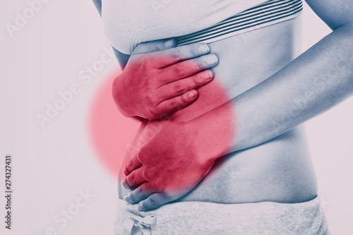 Stomach pain woman with red circle targeting painful area on lower abdomen body. Medical issue of gut health or crohn's disease, ibs syndrome and more. photo