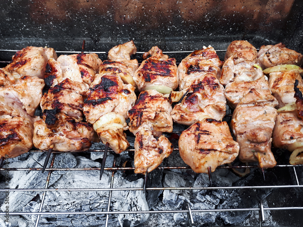Barbeque skewers meat kebabs on grill with beam and ash.  Close up food photo. Top view with copy space...