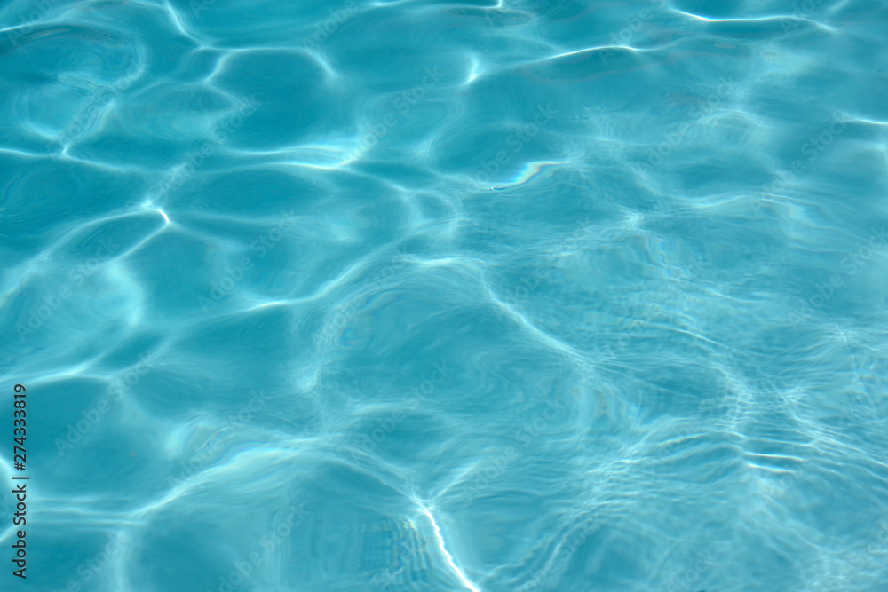 Close up full frame view of the reflecting water surface of a sunlit swimming pool