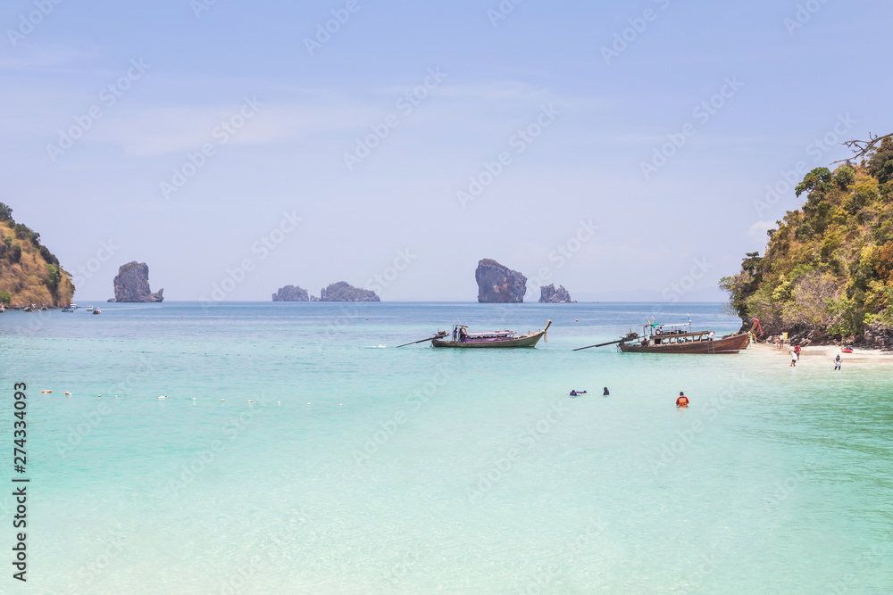 Fototapeta premium Longtail boats mooring on the beach at Tub island is Thale waek or separated sea in crystal clear water and miracle beach andaman sea Krabi, Thaiand 