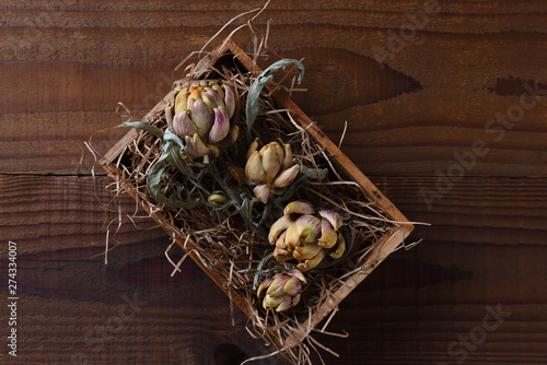 Dried Artichokes and leaves in a small wooden box with packing straw