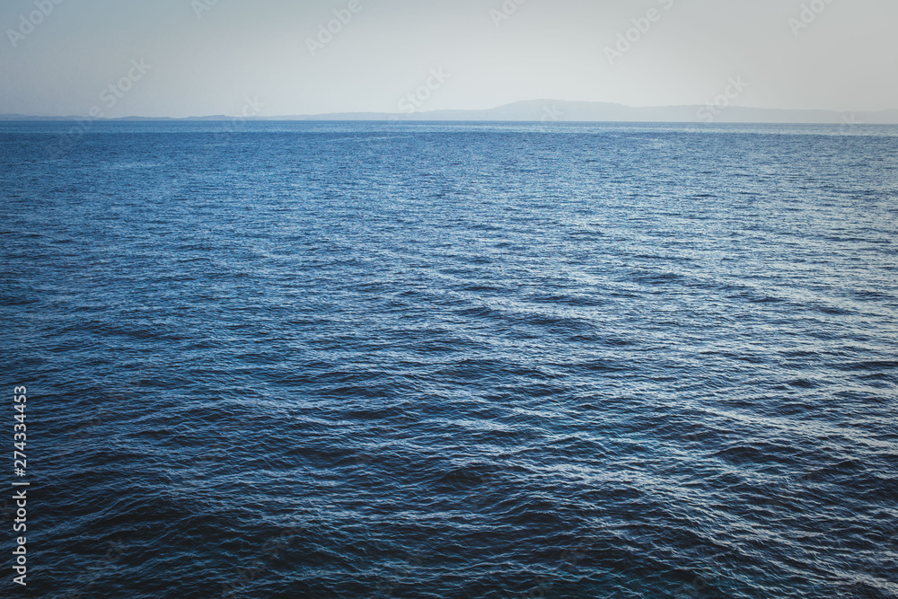 Seascape with sea horizon with calm deep blue water. Summer scenery