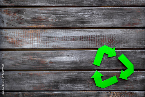 Recycling symbol for eco concept on wooden background top view copyspace