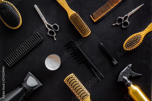 Hairdresser equipment for cutting hair and styling with combs, sciccors, brushes on black background top view pattern
