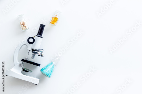 Do medical research with microscope, pills in test-tubes in lab on white background top view mock-up