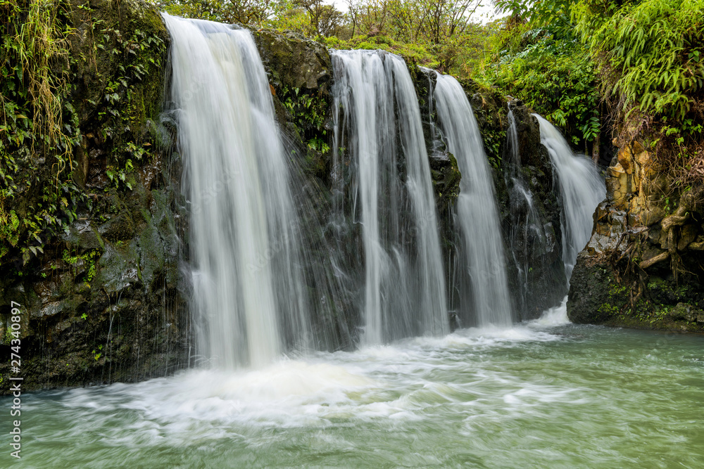 Waterfalls and Green Pond - Strong and broad waterfalls flowing into a clear green pond in Puaa Kaa State Wayside Park at side of the Road to Hana Highway, Maui, Hawaii, USA.