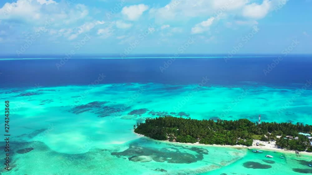 Maldives Atolls - aerial drone shot over coral reefs and uninhabited island, caribbean sea Maldives Atolls - aerial drone shot over coral reefs and uninhabited island, caribbean sea