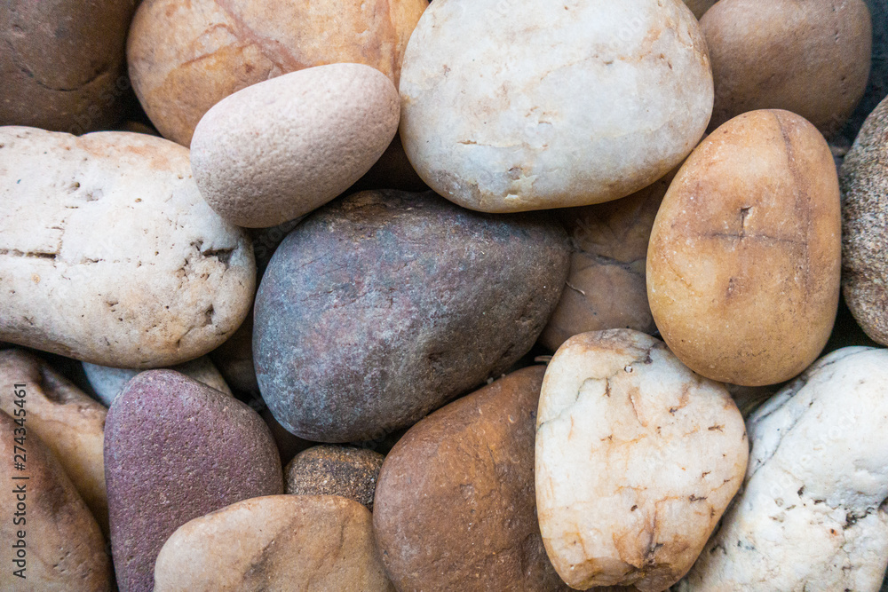 Small round rock stone most in light color. Close up. Background.
