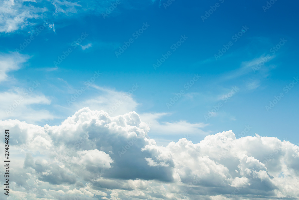 White fluffy thick clouds against the blue sky. Natural background wallpaper. The concept of clean air and ecology. White fluffy thick clouds against the blue sky. Natural background wallpaper. The concept of clean air and ecology.