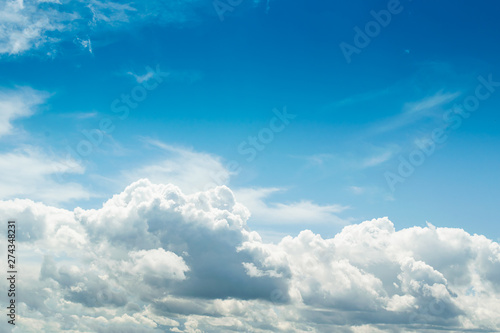 White fluffy thick clouds against the blue sky. Natural background wallpaper. The concept of clean air and ecology.
