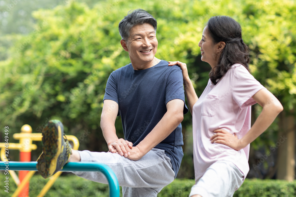 Happy mature couple exercising in park Happy mature couple exercising in park