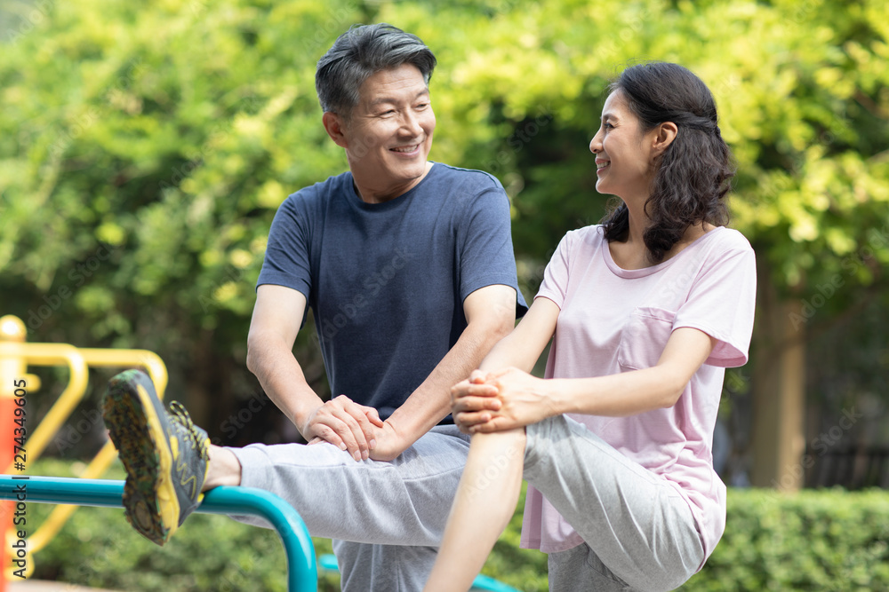 Happy mature couple exercising in park Happy mature couple exercising in park