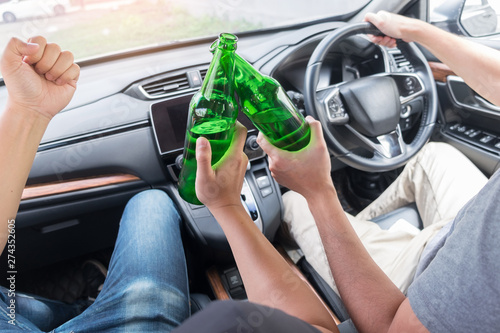 Don't Drink for Drive concept, Young Drunk man drinking bottle of beer or alcohol during driving the car dangerously