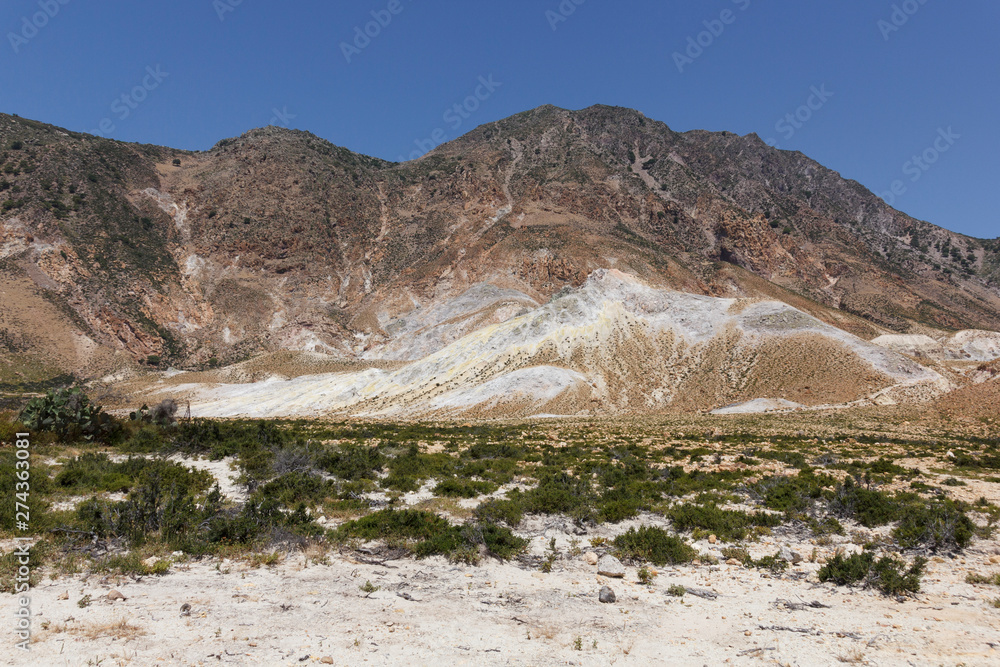 view of the Caldera of the volcano on Nisyros, a huge crater with snow-white sediments, sulfur crystals, from a height, the landscape around resembles a desert