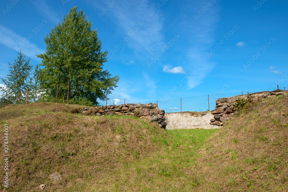 Remains of the foundation of an old wooden house on a summer day