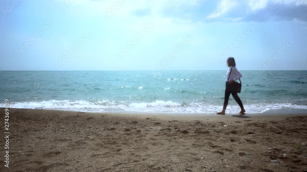 successful business woman in a business suit walking along the beach. concept - vacation. toned image. successful business woman in a business suit walking along the beach. concept - vacation. toned image.