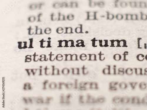 Dictionary definition of word ultimatum, selective focus. photo