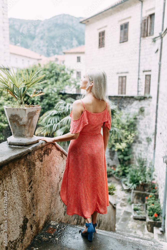 A beautiful girl in a red dress. Photo shoot on the evening streets of Kotor. A beautiful girl in a red dress. Photo shoot on the evening streets of Kotor.
