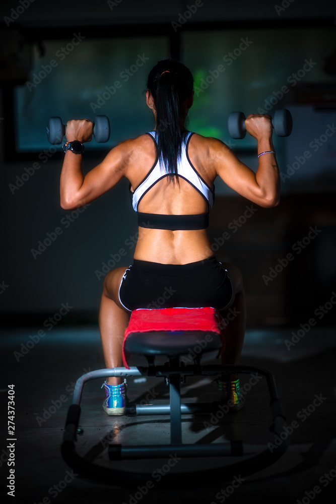 Amateur gym in the garage. A girl on the bench and weights Amateur gym in the garage. A girl on the bench and weights