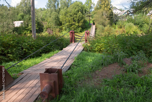 Suspension bridge over the river Belaya in the village of Lyubytino Novgorod region photo