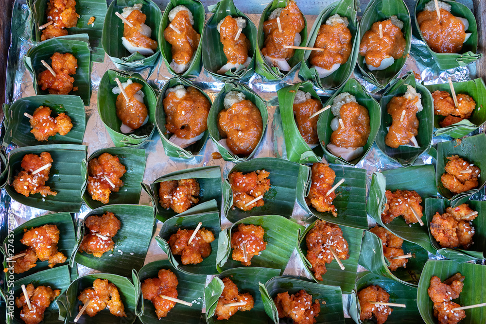 Traditional indonesian snack in green palm leaves . Close up. Asian food background, buffet table